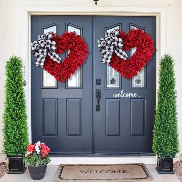 Heart-shaped wreath with plaid bow on front door